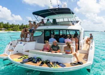 Boat tours Grand Cayman with tourists on deck viewing clear turquoise Caribbean waters and coral reefs