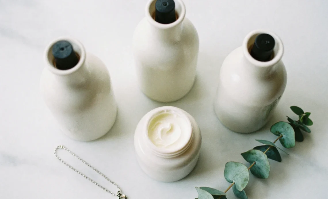 Best neck creams for anti-aging in a modern minimalist flat lay composition with skincare products and a necklace.