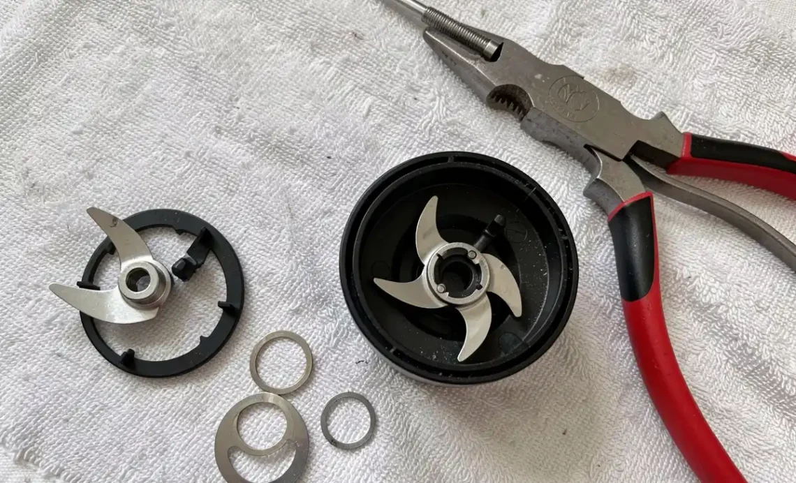 Close-up, professional photo showing how to sharpen Nutribullet blades, with disassembled parts and sharpening tools laid out on a clean surface.