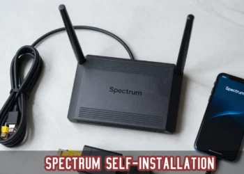 Complete Spectrum Internet self-installation kit including modem, router, cables, and a smartphone on a desk.