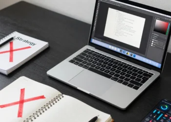 Graphic designer's desk showing a transition from traditional sketchbook to modern business strategy and UX tools.