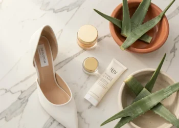 Flat lay of skincare essentials including cleanser, moisturizer, sunscreen, and aloe vera on marble surface, representing a complete daily skincare routine.