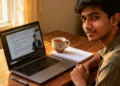 Laptop open on a wooden desk showing an online course video lecture with a coffee mug and notebook nearby, representing the benefits of flexible online education