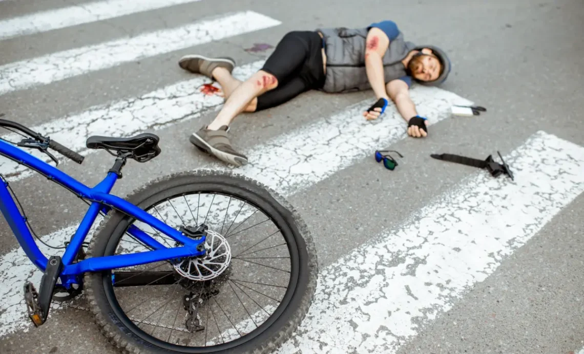 Confident cyclist standing with bicycle near law office building while checking lawyer contact information on smartphone after a Bicycle Accident Lawyer