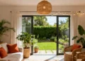 Warm living room with rattan pendant light connected to outdoor patio with wicker furniture and garden – home decoration tips for inside and out